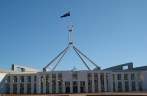 Australia's parliament house, including the flagpole, against a background of clear blue sky.