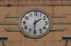 A photo of an art deco clock showing the time as 1:31. The clock features a white face with large black numbers and hour and minute hands.