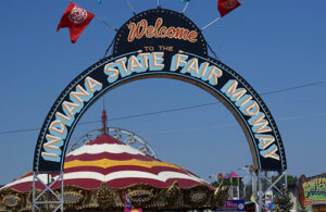 A large arch with the words, 'Welcome to the Indiana State Fair Midway' painted on it.