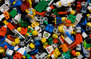 Lego minifigures and pieces of Lego lie in a pile.