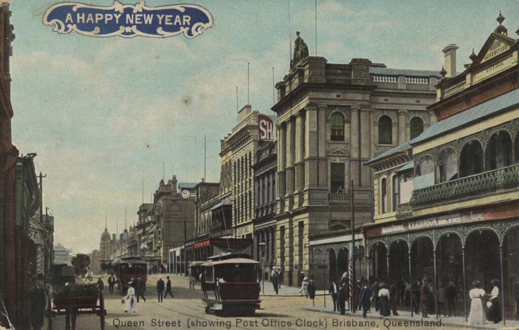 A postcard featuring a coloured black and white photo of Queen Street, Brisbane, circa 1908. It includes a number of historic buildings, including the post office with a large clock in view.