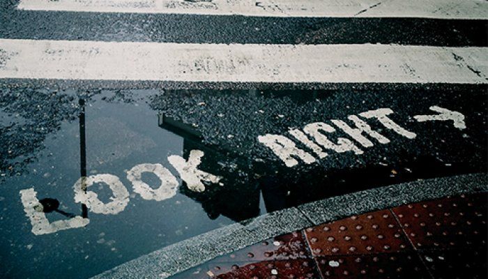 White words reading 'Look right' are on the surface of a bitumen road.