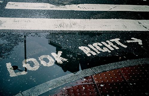 White words reading 'Look right' are on the surface of a bitumen road.